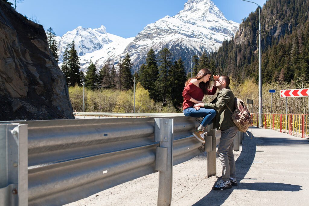 young hipster beautiful couple in love, sitting at road, swag outfit, autumn vacation, romance, trendy style, having fun, smiling, traveling, hiking zurich airport layover tour